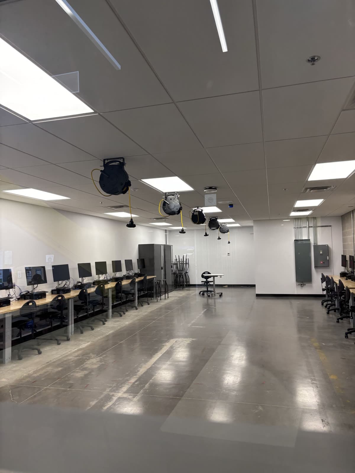 Training lab fit-up — overhead cord reels, lighting and panels